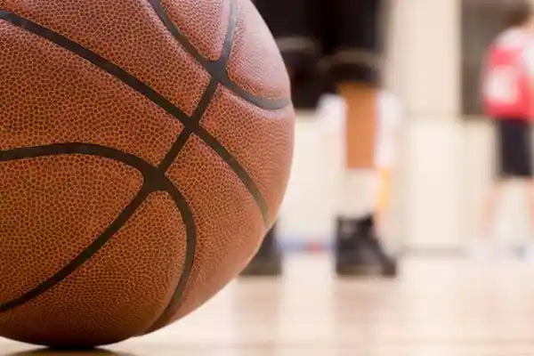 A basketball on a court with a player in the background