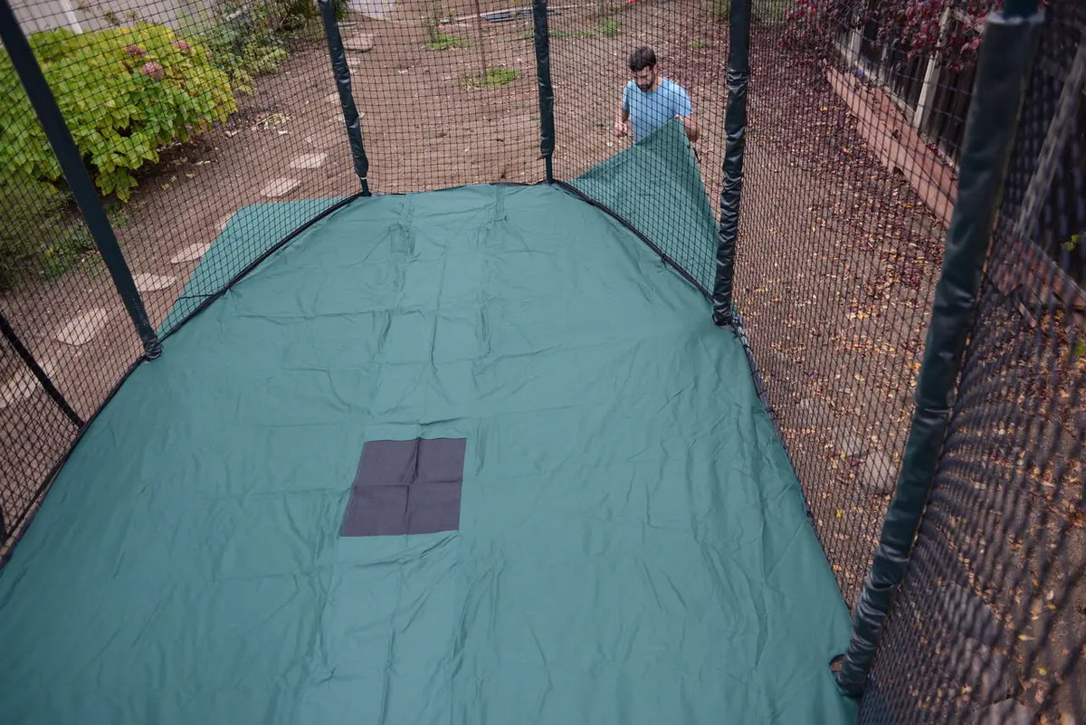 A rectangle cover on a trampoline.The JumpSport trampoline weather cover guards your trampoline from harmful UV rays and keeps the temperature cooler on the mat! Protect your investment now.